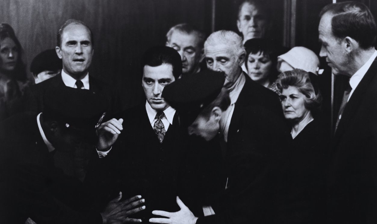 Gettyimages - 526898034, Al Pacino in The Godfather: Part II Michael Corleone (Al Pacino) is frisked as he enters court for a senate investigation into organized crime as Tom Hagen (Robert Duvall, left) waits his turn in Francis Ford Coppola's The Godfather: Part II.