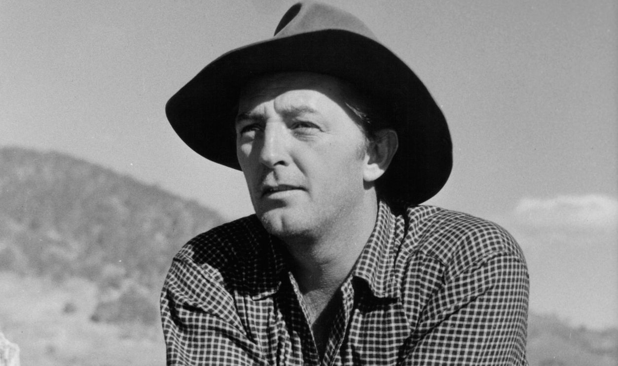 Robert Mitchum leans on a fence in a scene from the film 'The Sundowners', 1960. 