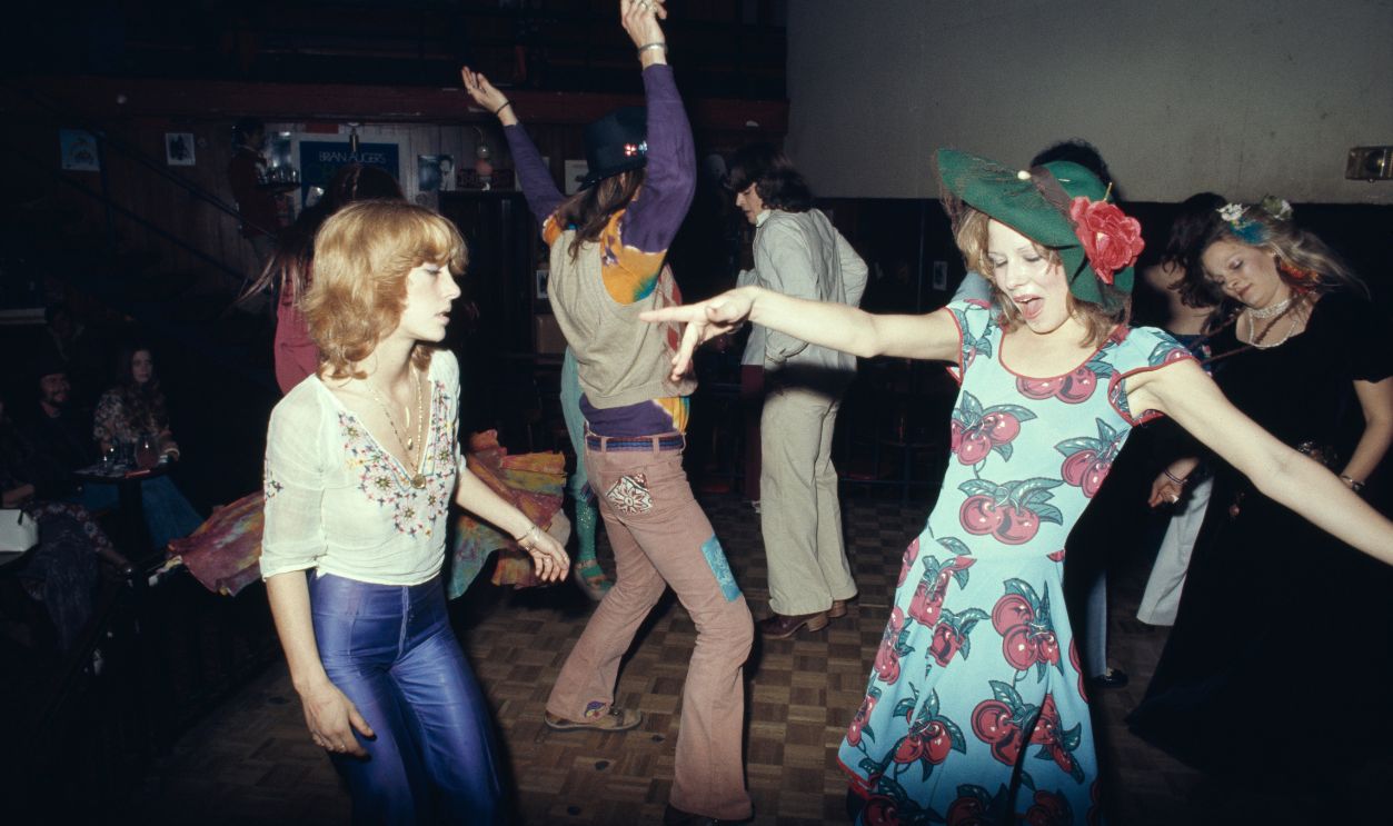 Clubbers on the dancefloor, with one woman wearing a blue dress with cherry motifs and a green hat with a red flower, at the Whisky a Go Go, a nightclub on Sunset Boulevard in West Hollywood, California, circa 1975.