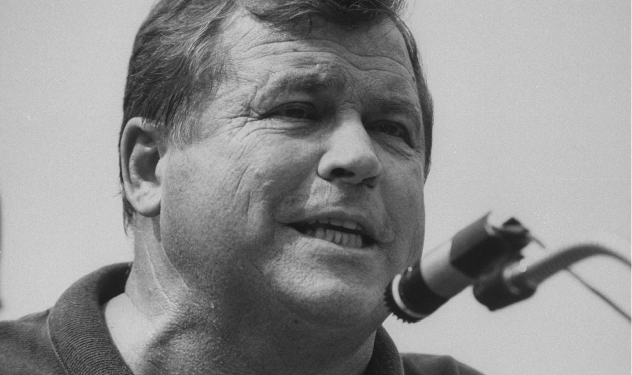 Ex-actor/self-proclaimed pres. cand. Tom Laughlin talking into mike as he makes speech to a rally of students protesting cuts in the education budget on the campus of the Univ. of Iowa during his campaign tour of the state. 