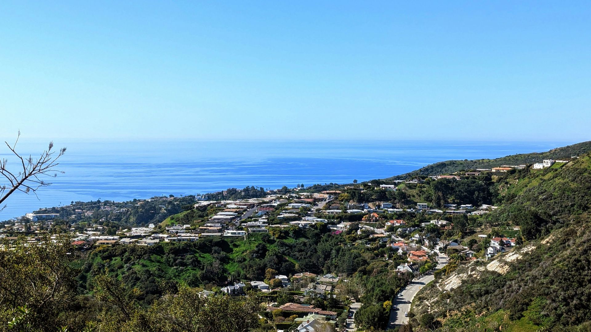 a view of a town on a hill with a body of water in the background