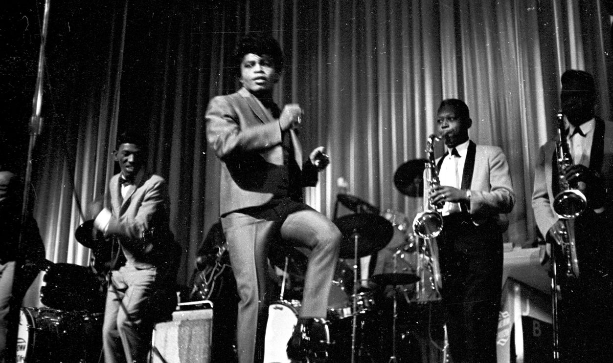 "Godfather of Soul" James Brown performs with The Famous Flames (on left, Johnny Terry, Bobby Byrd, Bobby Bennett) at the Apollo Theater in 1964 in New York, New York.