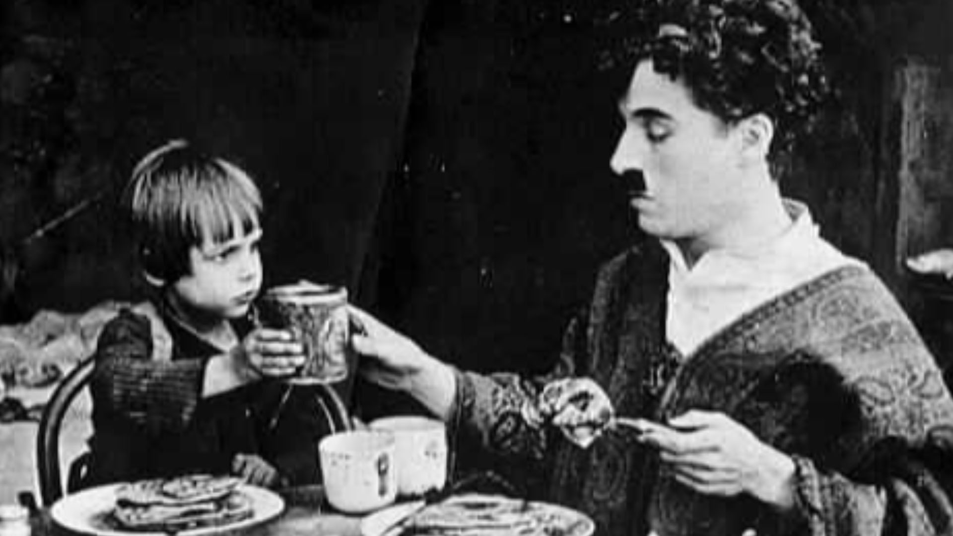 Film still from The Kid (1921) of Charles Chaplin for Charles Chaplin Productions. With Jackie Coogan.