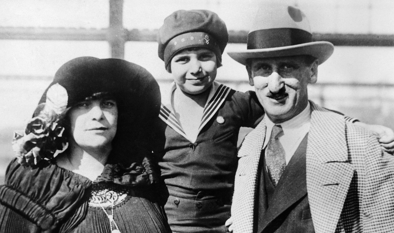 Getty Images - 105215974 - The Young American Actor Jackie Coogan Standing Between His Parents Lillian Dolliver And Jack Coogan Sr. (Both Actors) On The Ocean Liner Le Majestic, Between 1920 And 1922.