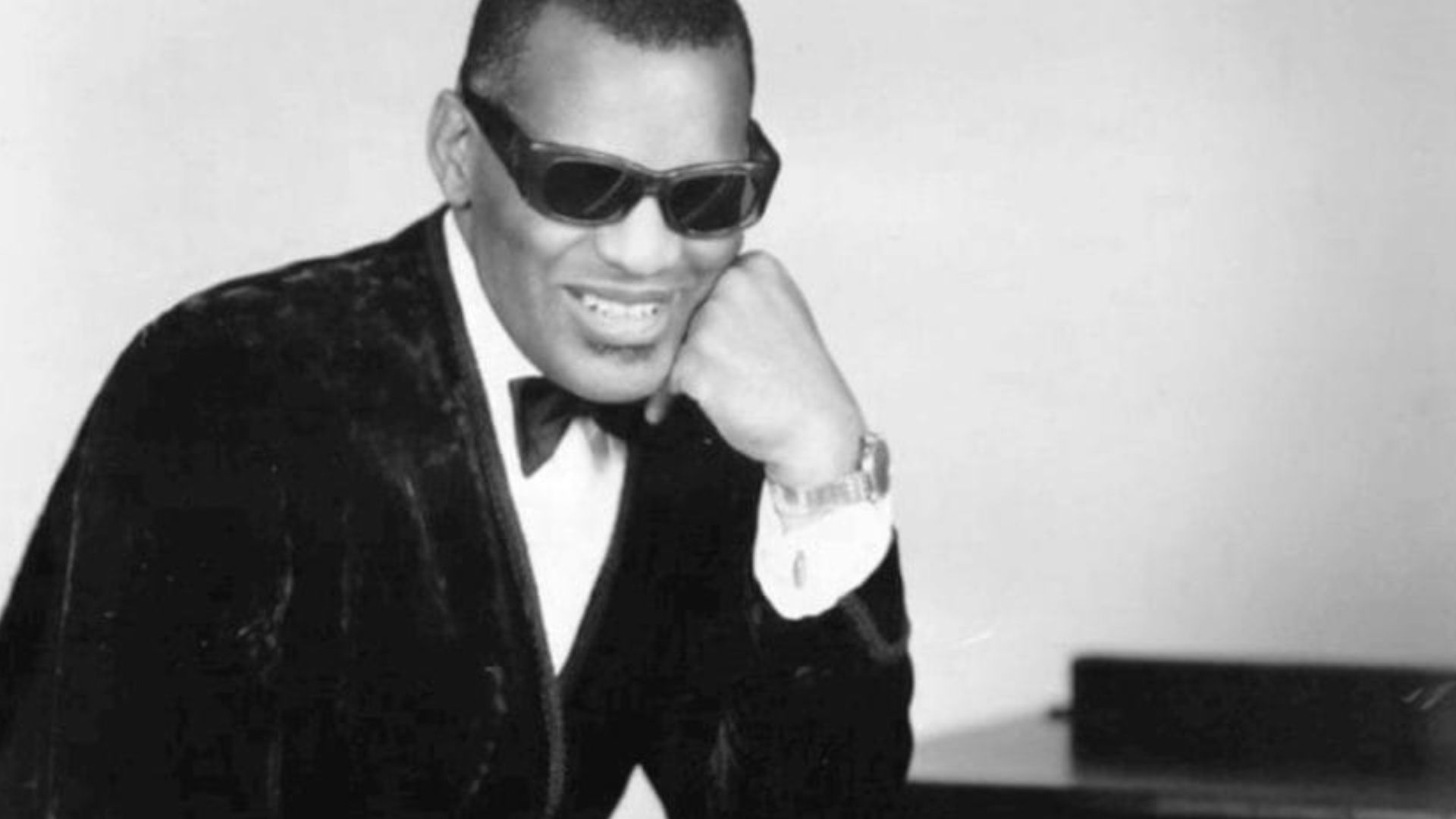 Photo of Ray Charles in one of his classic poses at the piano.
