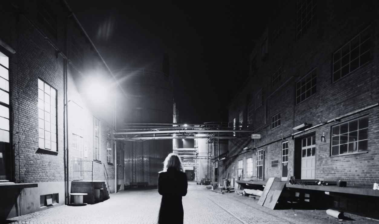 Back View of a Woman Walking on Street at Night