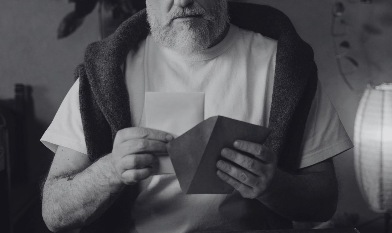 A Man Placing a Letter in an Envelope