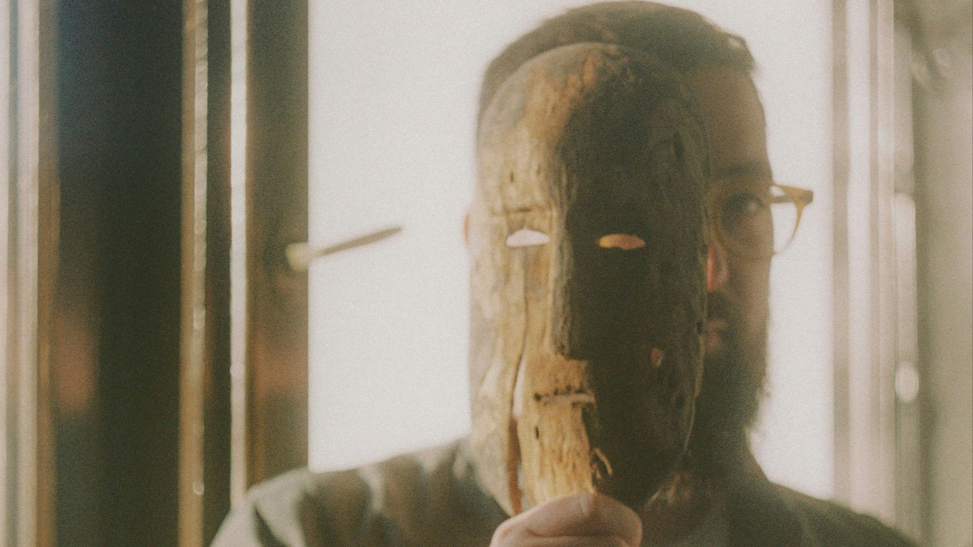 man in gray long sleeve shirt holding brown wooden stick