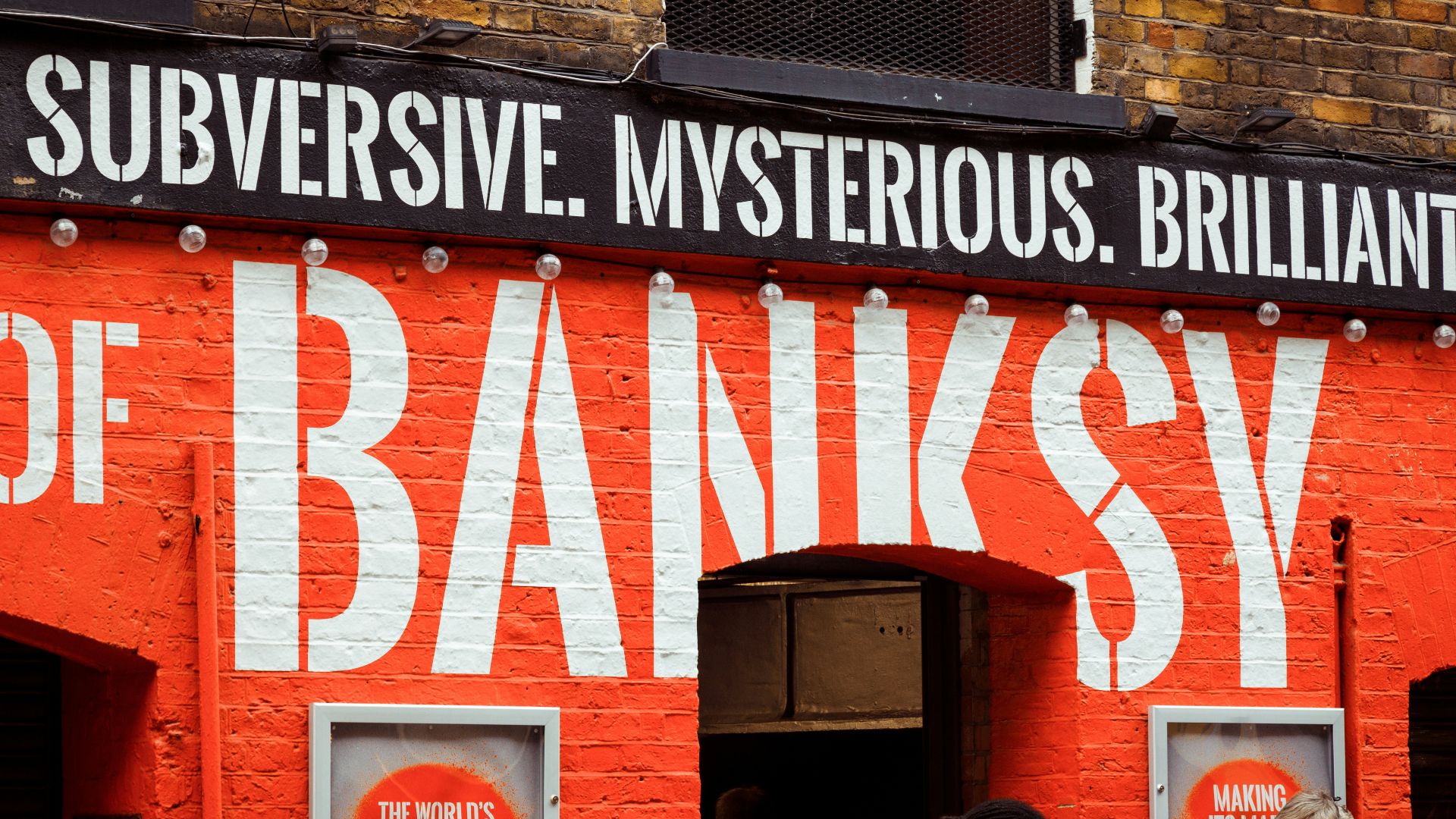 woman in black jacket standing beside brown wooden door during daytime