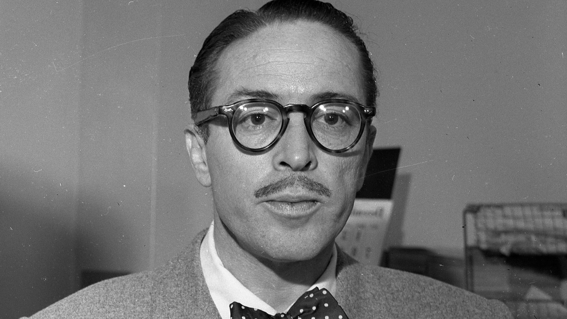 GIVES SELF UP—Dalton Trumbo, film writer, left, pictured with Dep. U.S. Marshal Rossini on surrender in contempt of Congress case. He was released on bond.