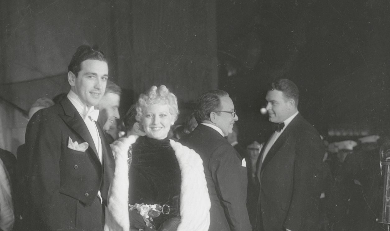Thelma Todd with Her Husband (Original Caption) Hollywood California: Miss Thelma Todd with her husband. Miss Todd wore a striking black velvet gown with white ermine coat.