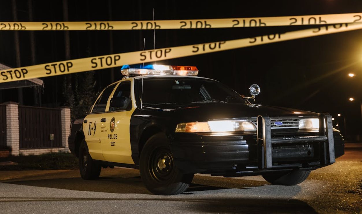 A Police Car Parked Beside the Crime Scene