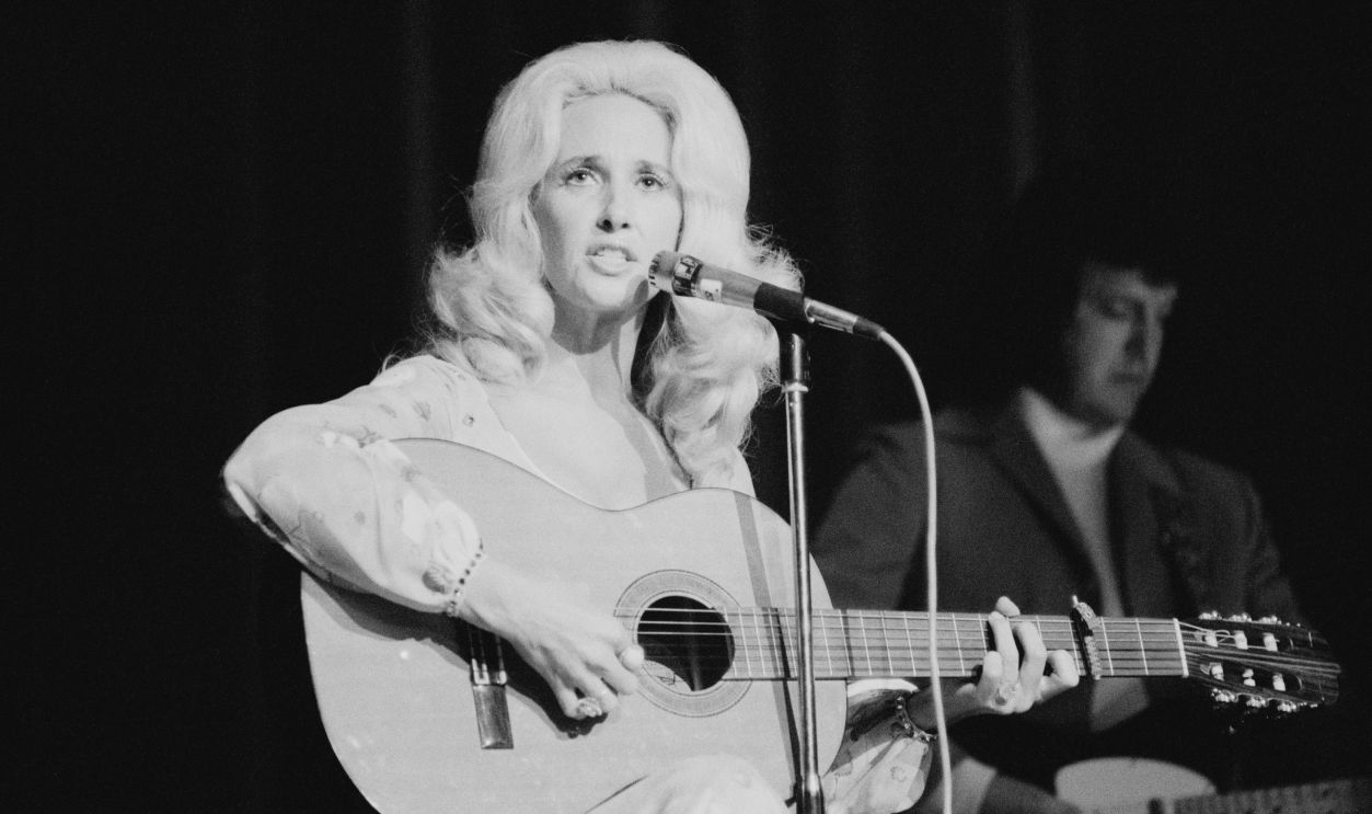 American country music singer-songwriter Tammy Wynette (1942 - 1998) performing at the Hammersmith Odeon, London, June 1975.