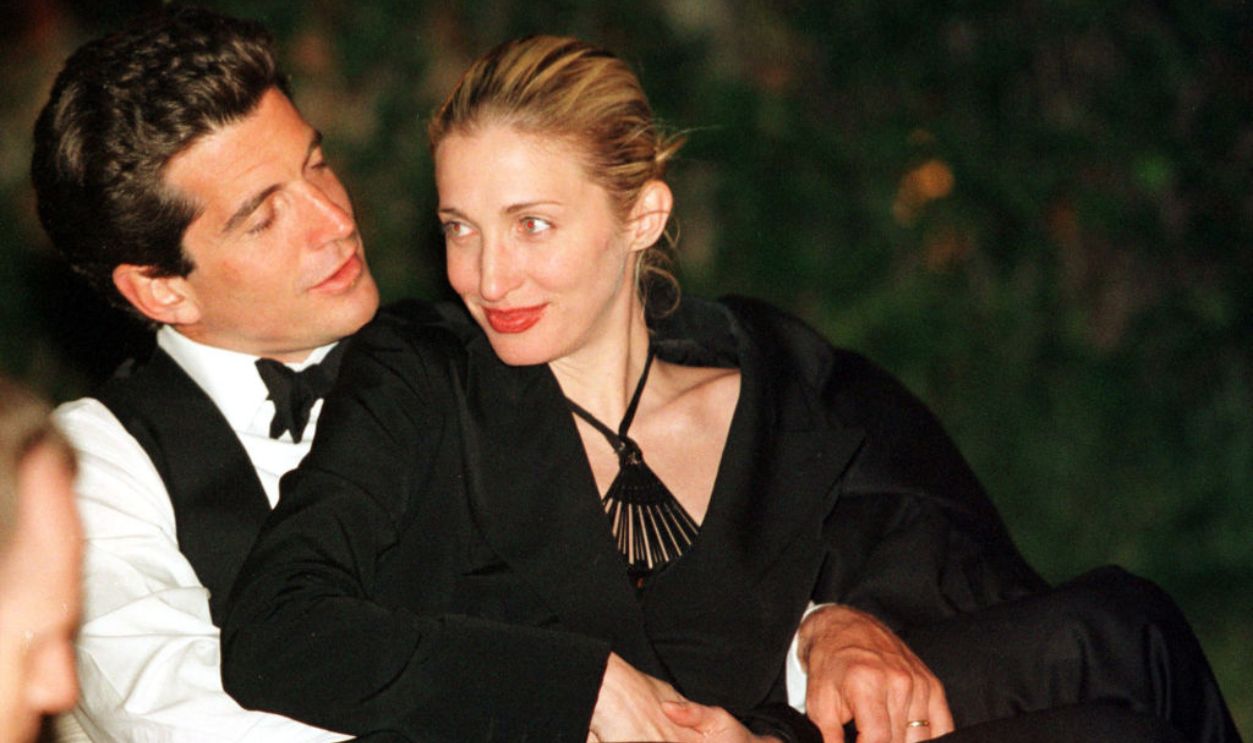 John F. Kennedy, Jr., (1960 - 1999) editor of George magazine, sits with his wife Carolyn Bessette (1966 - 1999) on his lap during the annual White House Correspondents dinner in Washington, DC., May 1, 1999. 