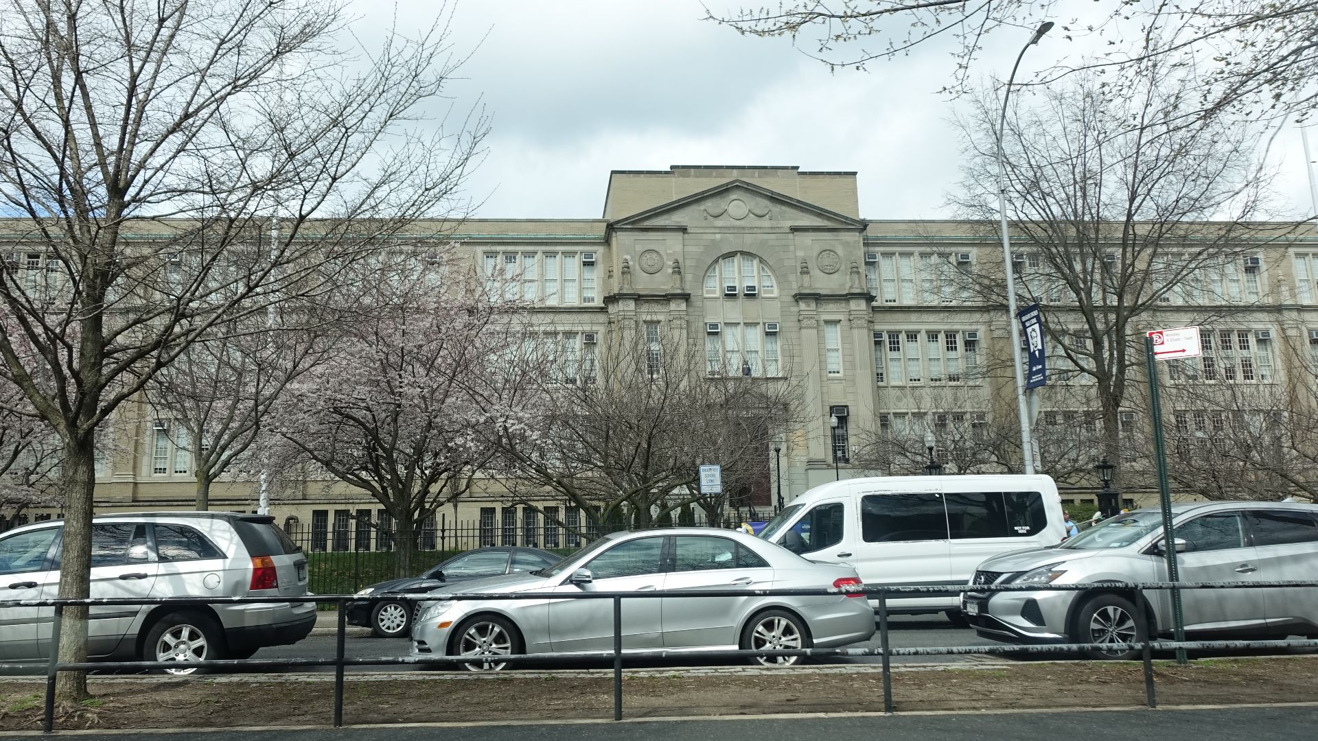Looking at the front or eastern face of Abraham Lincoln High School, at the northwest corner of Ocean Parkway and West Avenue (Mitchell Wesson Place) in Coney Island, Brooklyn. The building shares a common (nearly identical) E-shaped design and stone façade with several Depression-era high schools, including Bayside High School in Queens.