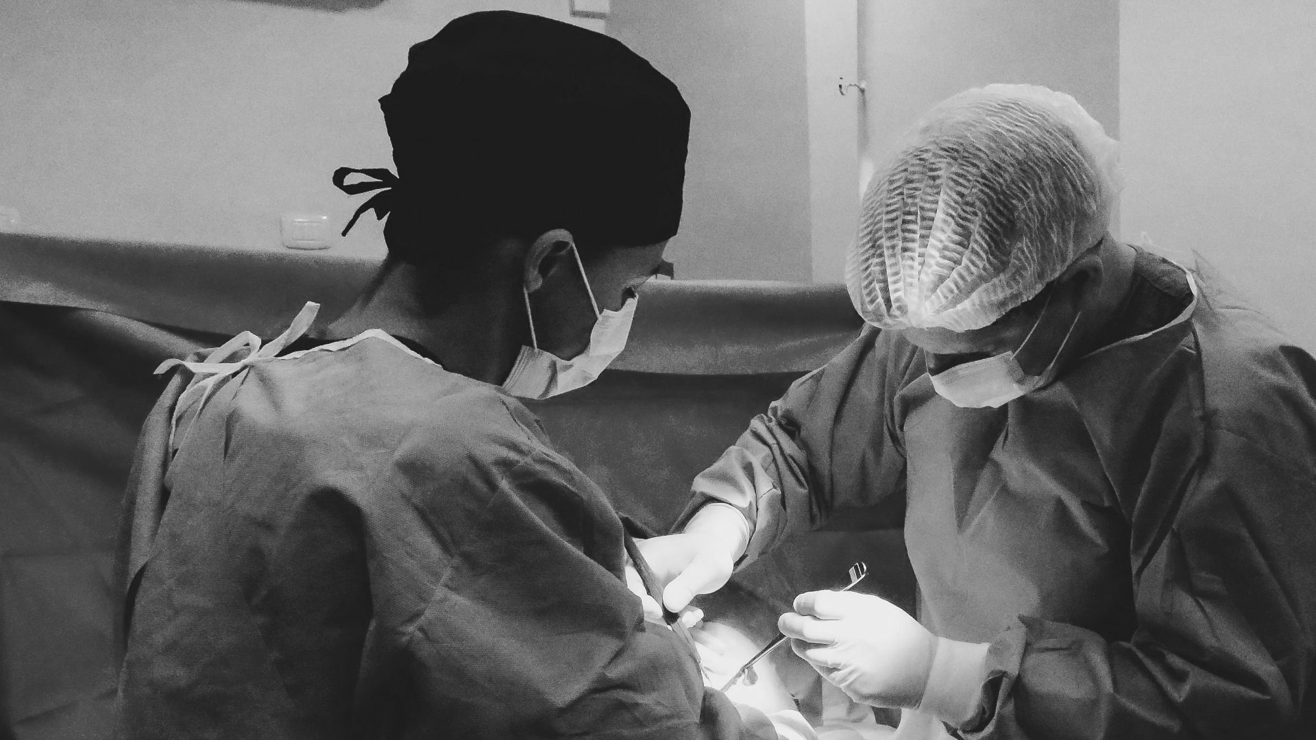 Surgeons focusing on a procedure in an equipped operating room, showcasing teamwork and precision.