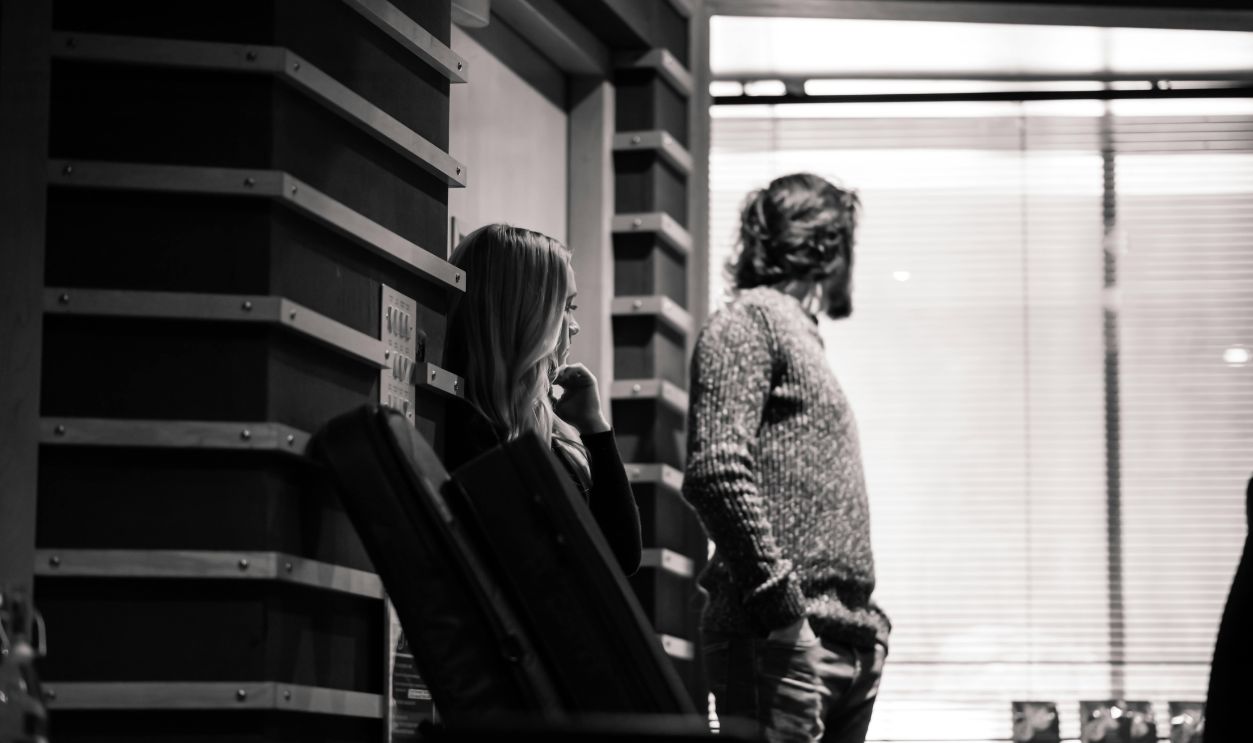 A man and woman standing in front of a window