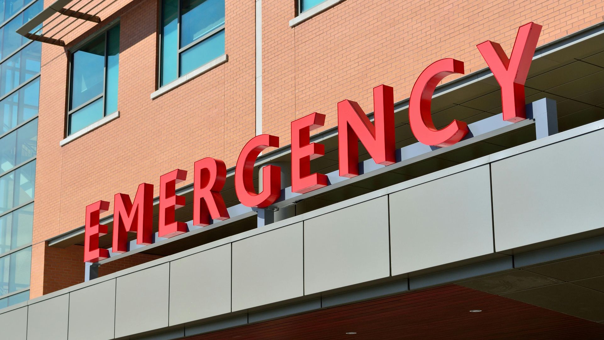 Close-up of a modern hospital emergency room entrance with prominent red letters.