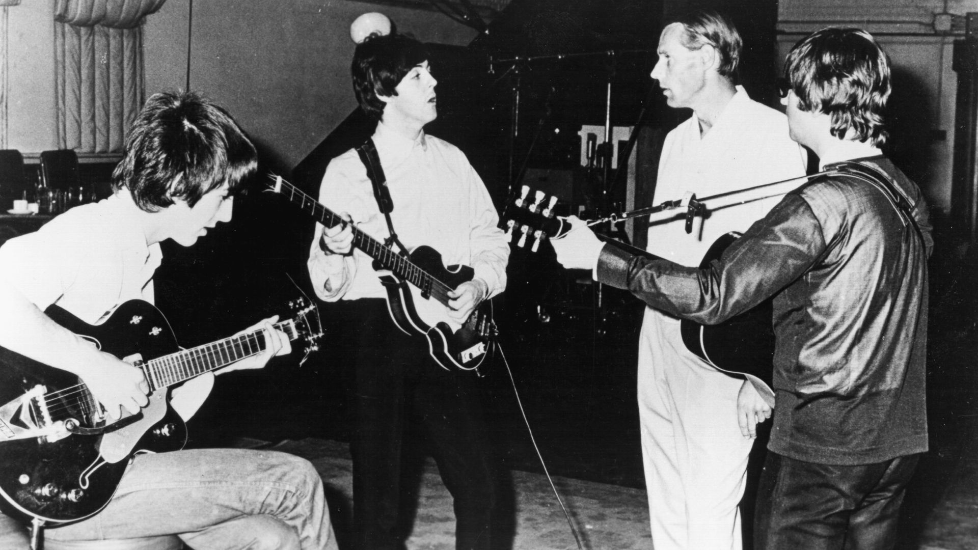 Publicity photo of the Beatles with producer George Martin in the studio at Abbey Road. Only John Lennon, George Harrison and Paul McCartney are pictured.