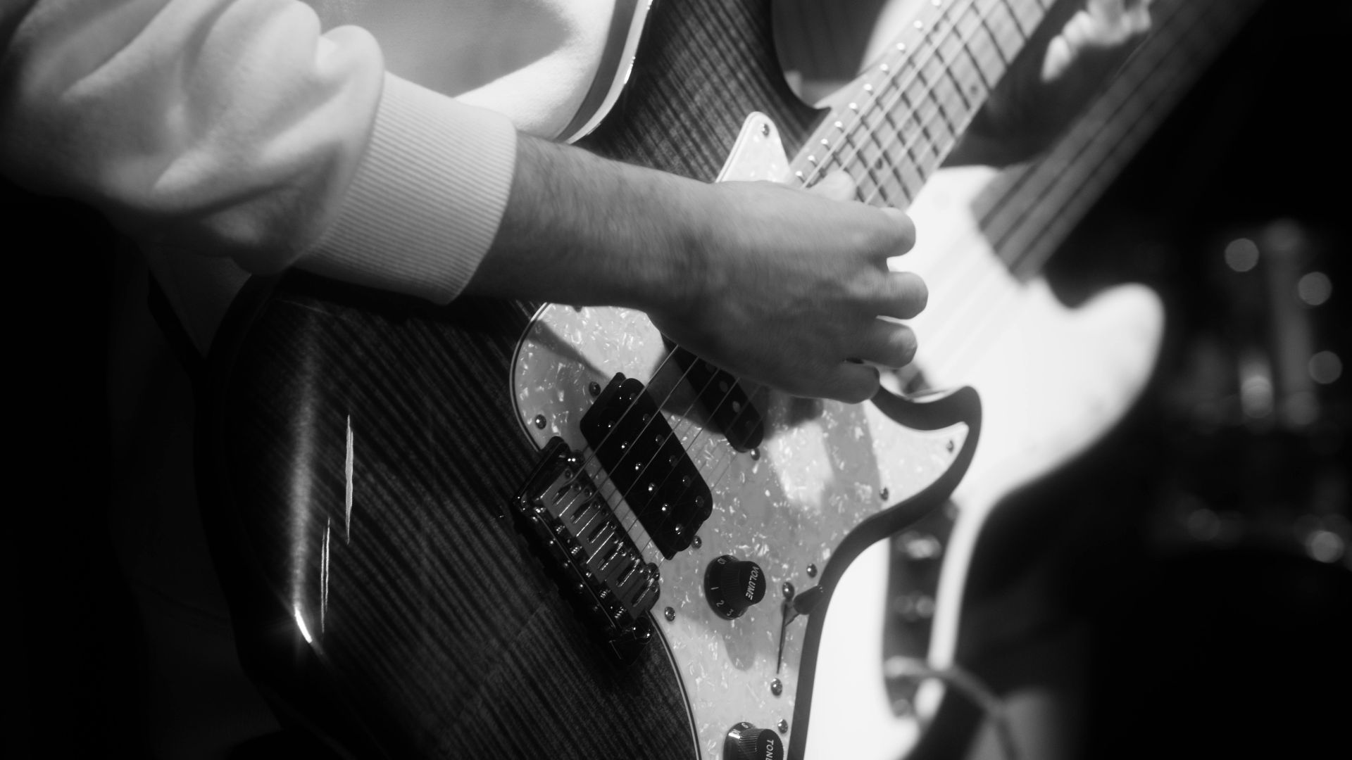 Black and white photo capturing a musician playing an electric guitar at a rock concert in Ankara.