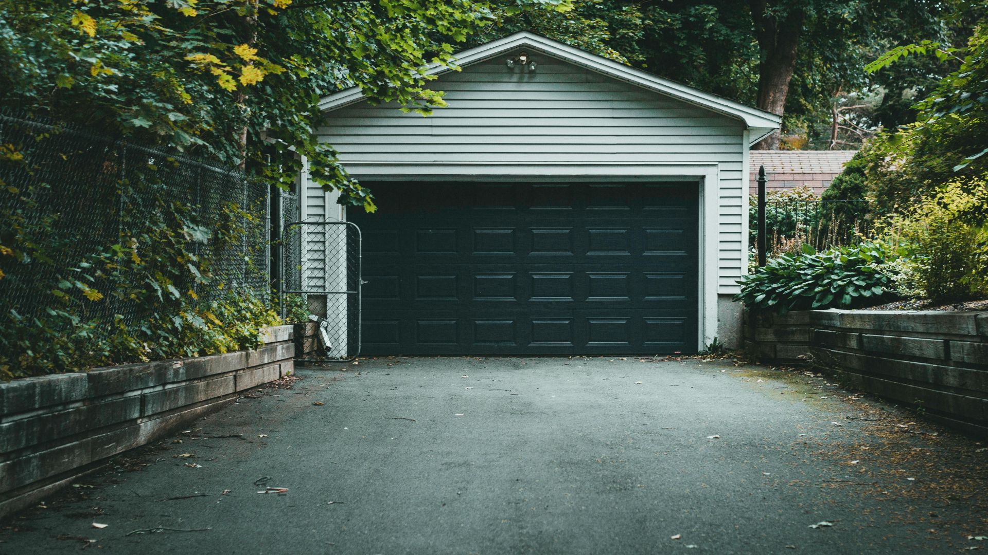 A scenic garage with lush greenery and a driveway, perfect for residential and nature-themed content.