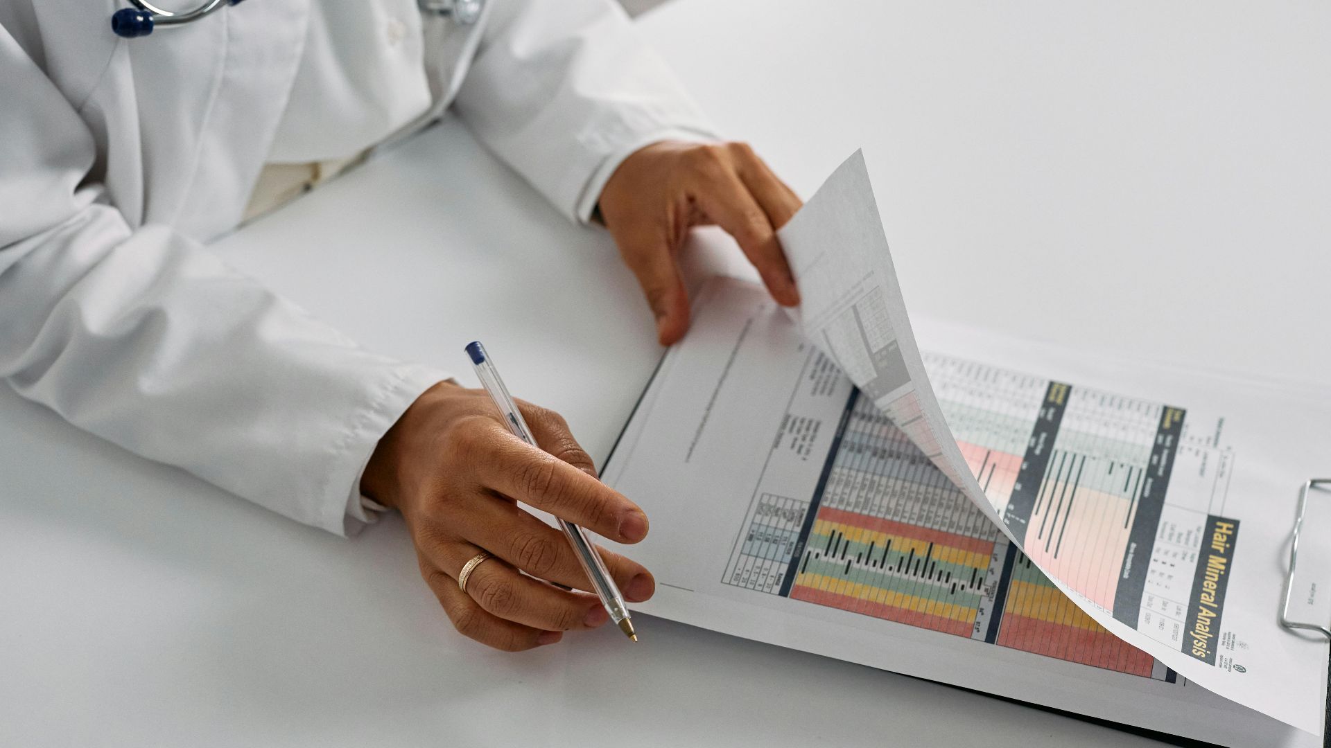 A medical professional checking patient reports with a clipboard in an office setting.