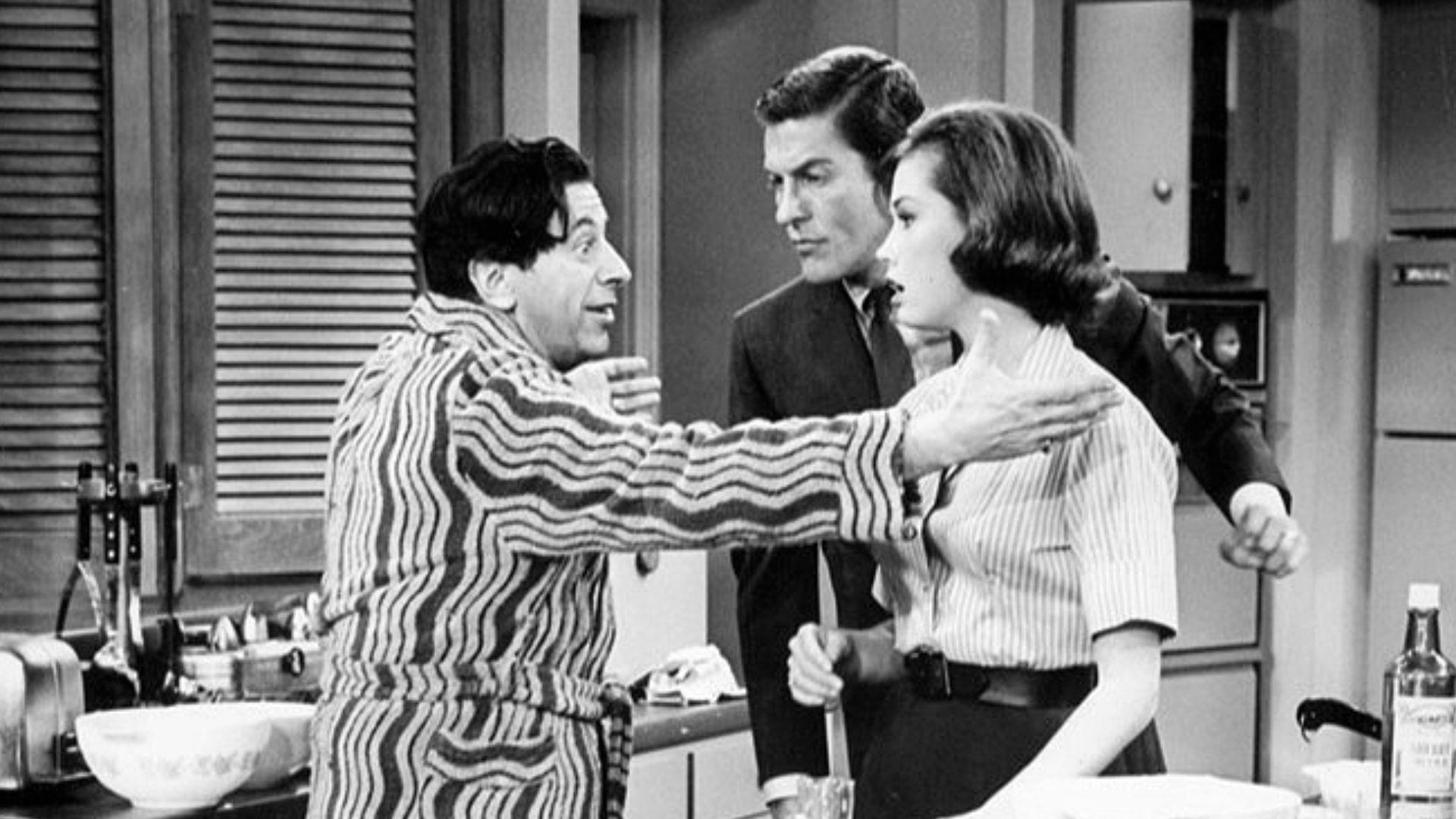 Publicity photo from The Dick Van Dyke Show. Pictured are Buddy (Morey Amsterdam) and Laura (Mary Tyler Moore) and Rob (Dick Van Dyke) Petrie. When Buddy's wife, Pickles, goes out of town, Buddy becomes the Petrie's house guest.