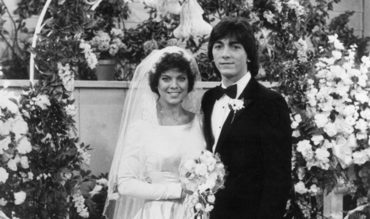 2696492 - American actors Erin Moran, wearing a wedding dress, and Scott Baio, wearing a tuxedo, pose at an altar in a promotional portrait from the TV program 'Happy Days.'  