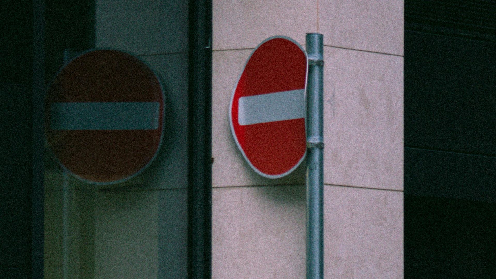 Vertical shot of an urban no entry sign on a modern city street corner.