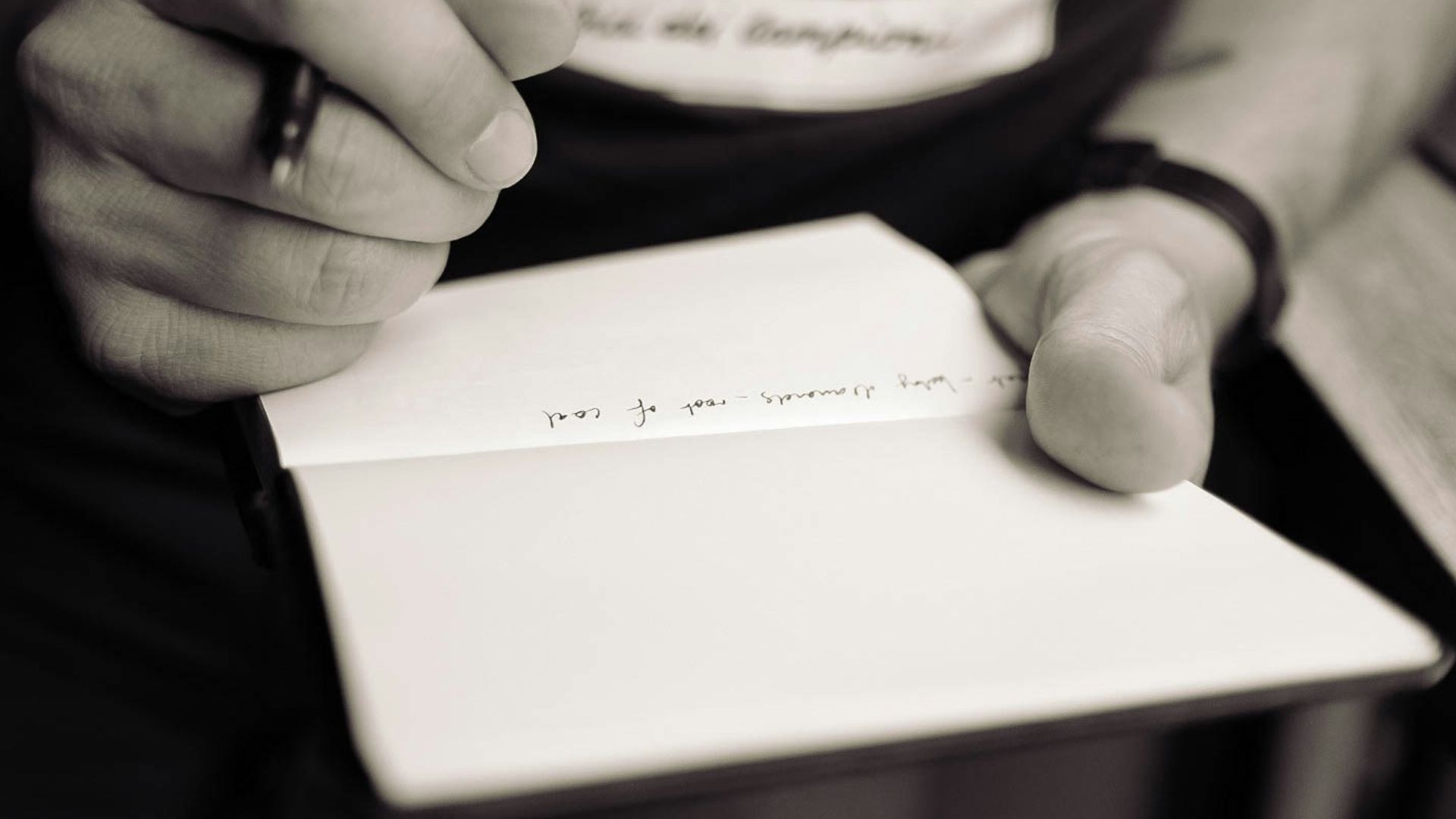 person writing on notepad