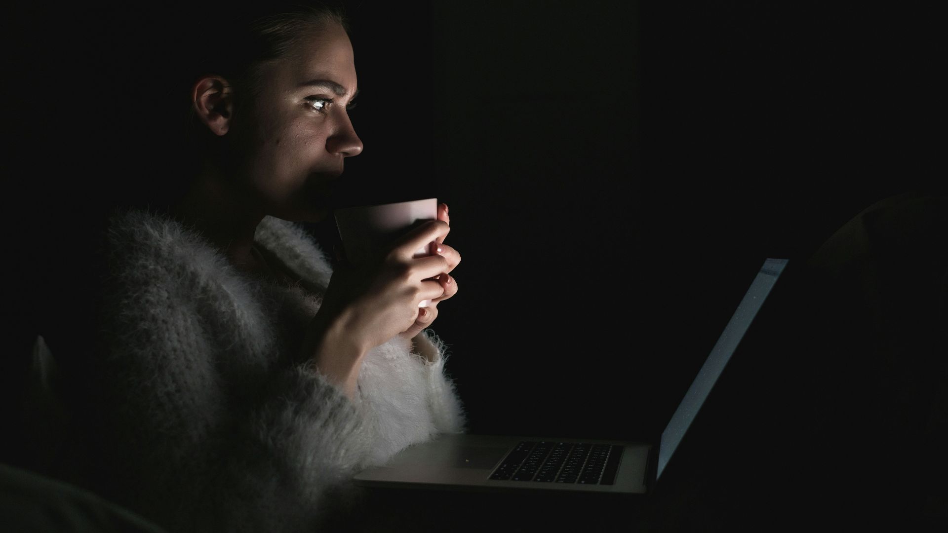 a person sitting in front of a laptop
