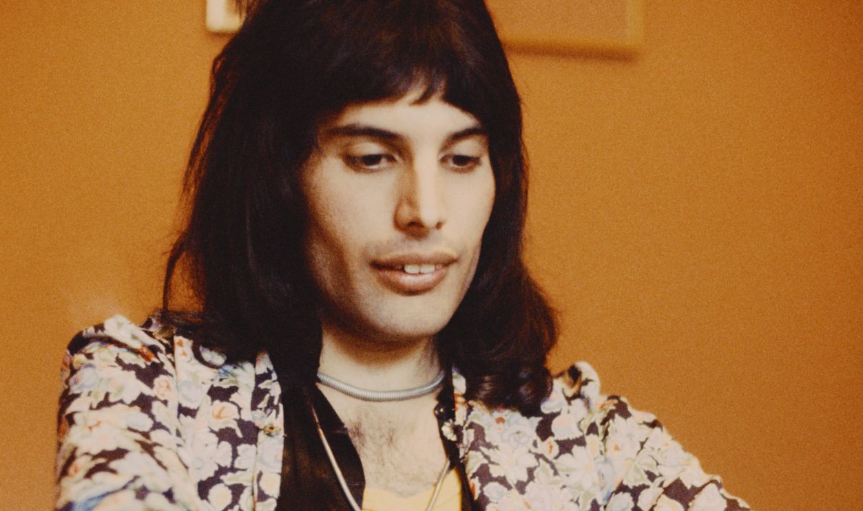 Freddie Mercury Of Queen Singer Freddie Mercury (1946 - 1991) of British rock group Queen pictured sitting at a table on 12th February 1974. 