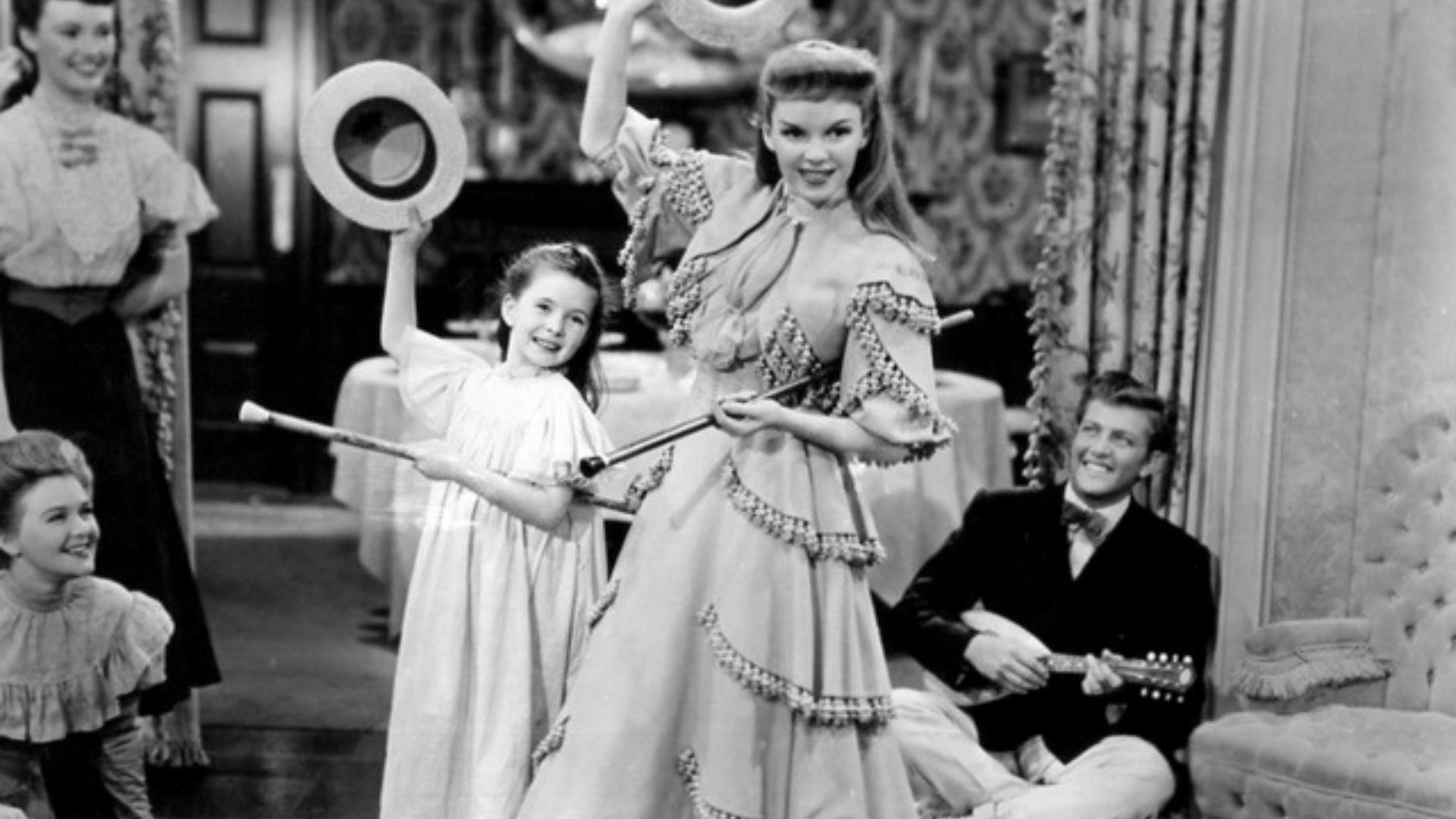 Promotional still from the 1944 film Meet Me in St. Louis, starring Judy Garland with Margaret O'Brien. Seated on right is Henry H. Daniels Jr.