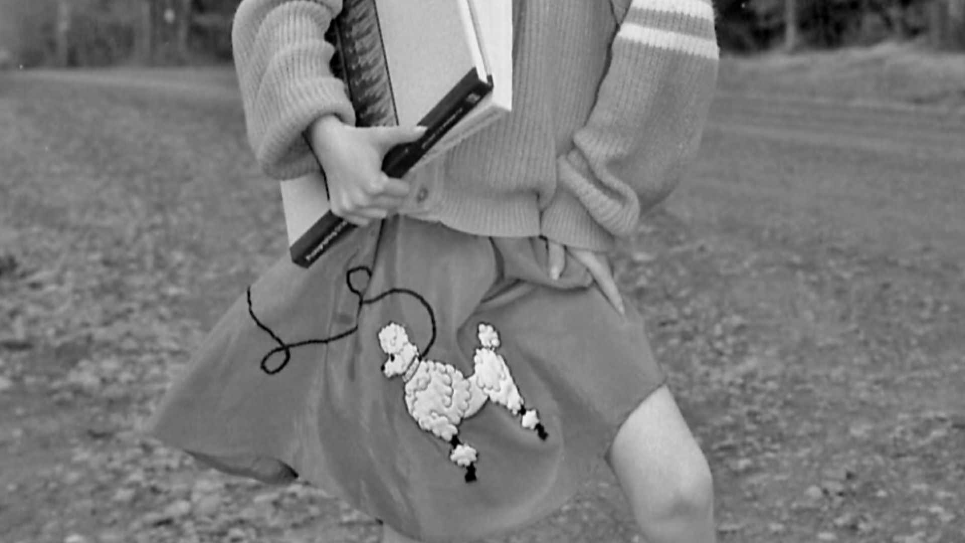 Young girl wearing a poodle skirt and saddle shoes.