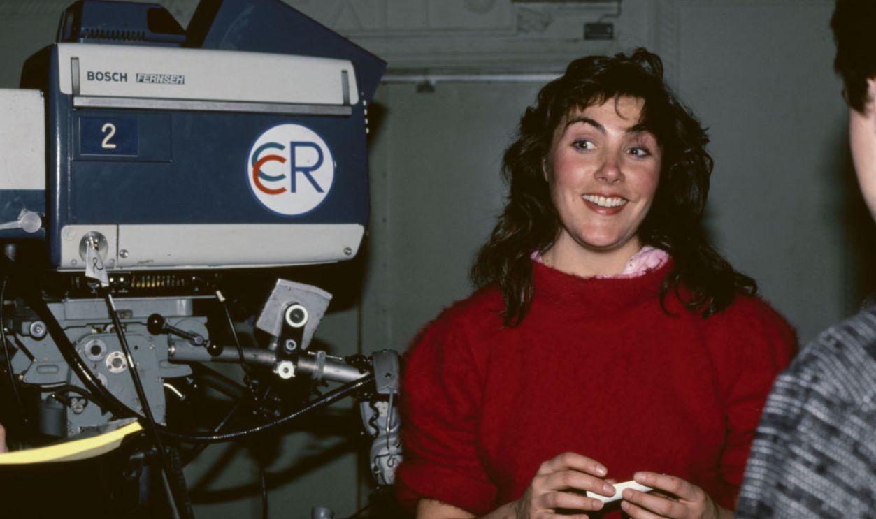 American singer and songwriter Laura Branigan (1952-2004) smiling beside a Bosch Fernseh KCK-40 television camera on which is an 'CCR' logo, possibly in New York City, circa 1983.