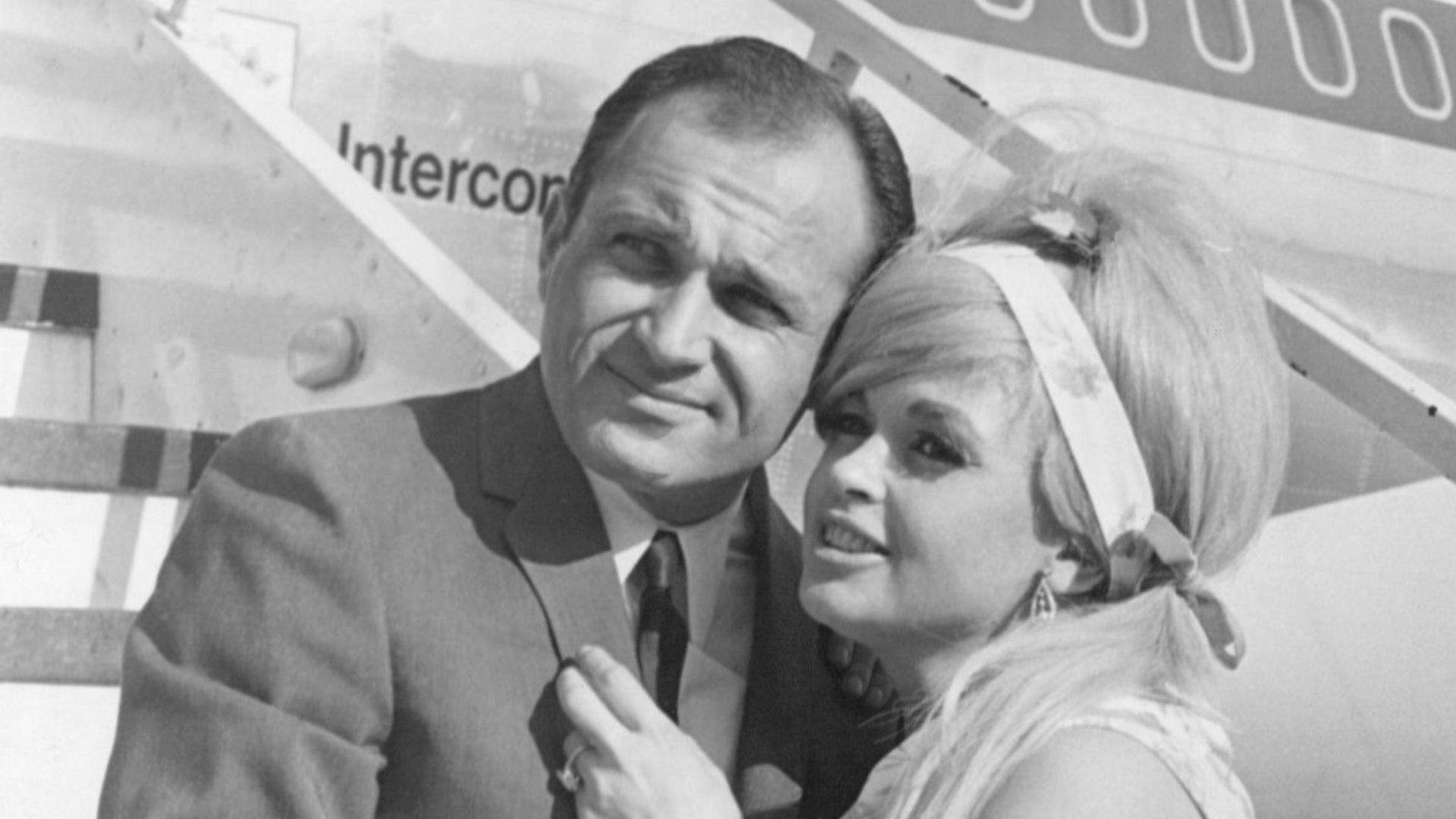 Photo of Jayne Mansfield and her lawyer-boyfriend Sam Brody posing for a photo before a trip to Frankfurt am Main, Germany, where Mansfield was to do some television work. This photo was taken at Chicago's O'Hare airport; Mansfield and Brody arrived from Los Angeles to make their transatlantic air connection. About six weeks after this photo was taken, Mansfield and Brody died, along with the driver of their car, in an auto-truck crash in Louisiana. This is probably one of the last photos of Mansfield.