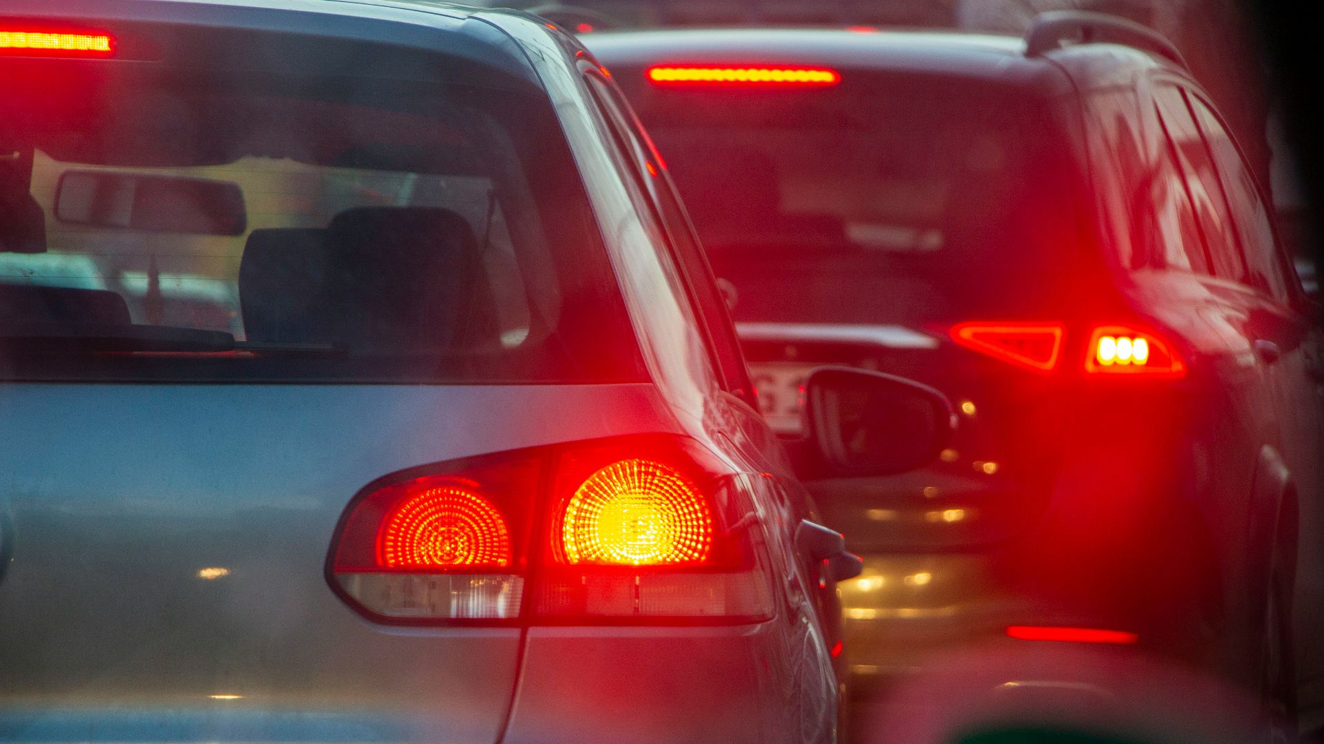 a group of cars driving down a street next to each other