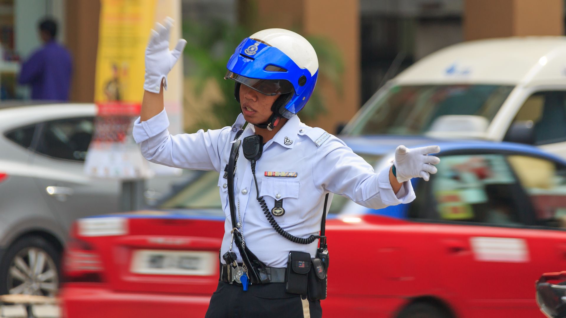 Kuala Lumpur, Malaysia: Traffic police officer regulating the traffic at intersection Jalan Pudu / Jalan Imbi