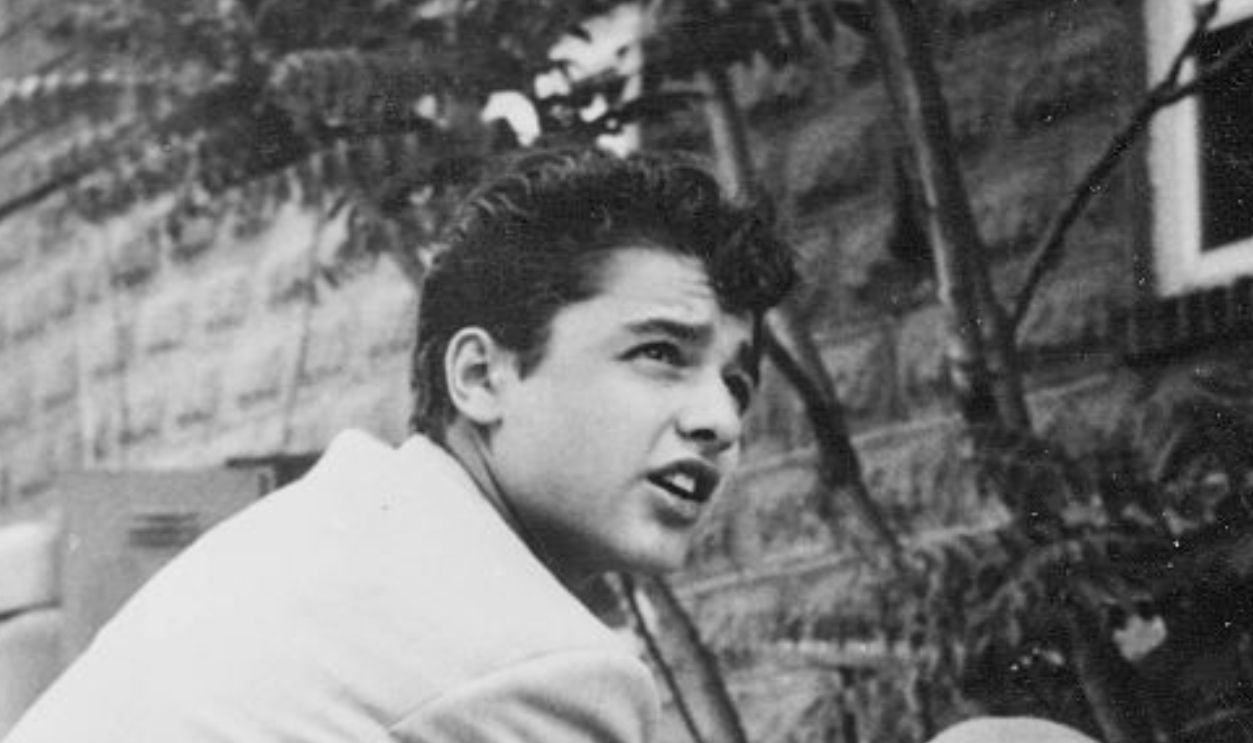 Actor Sal Mineo with a chained dog, 1954.