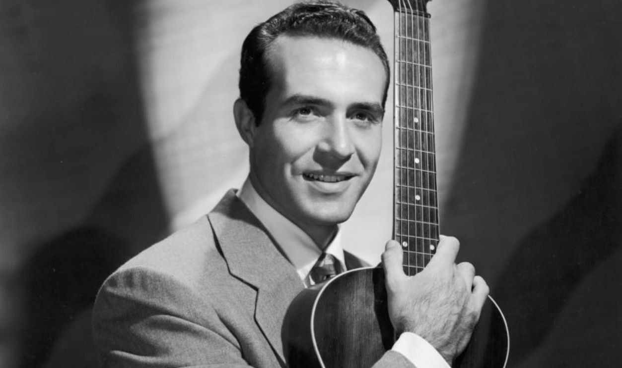 circa 1945: Portrait of Mexican-born actor Ricardo Montalban, holding an acoustic guitar upright.