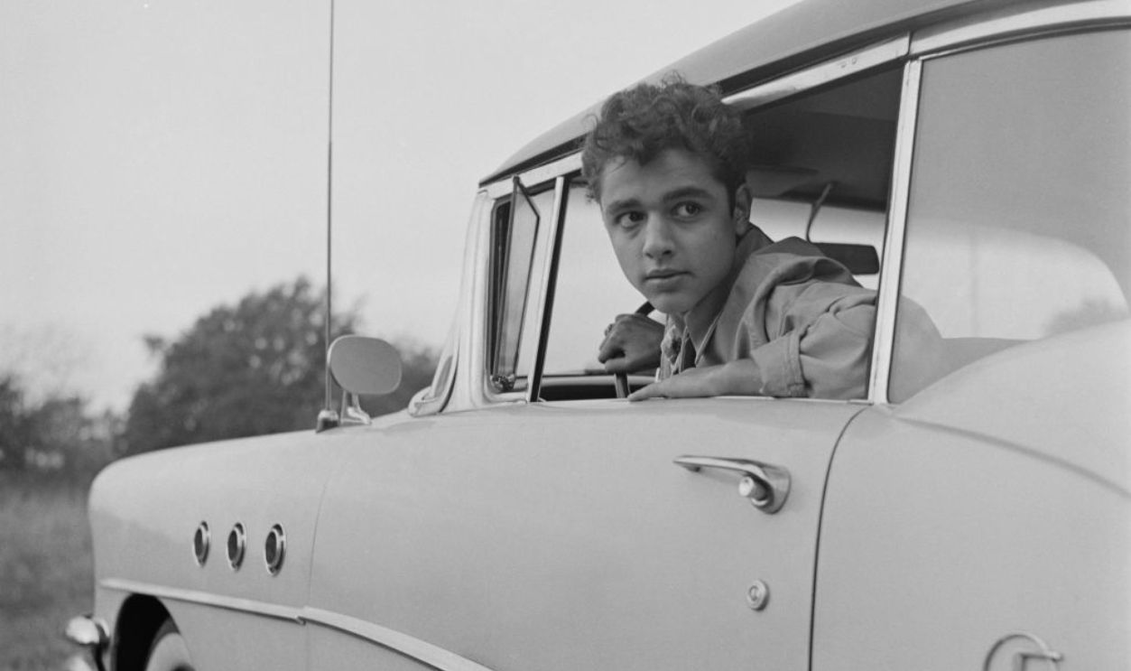 American actor Sal Mineo (1939 - 1976) on a car outside his family home in the Bronx, New York City, US, 1st November 1955.
