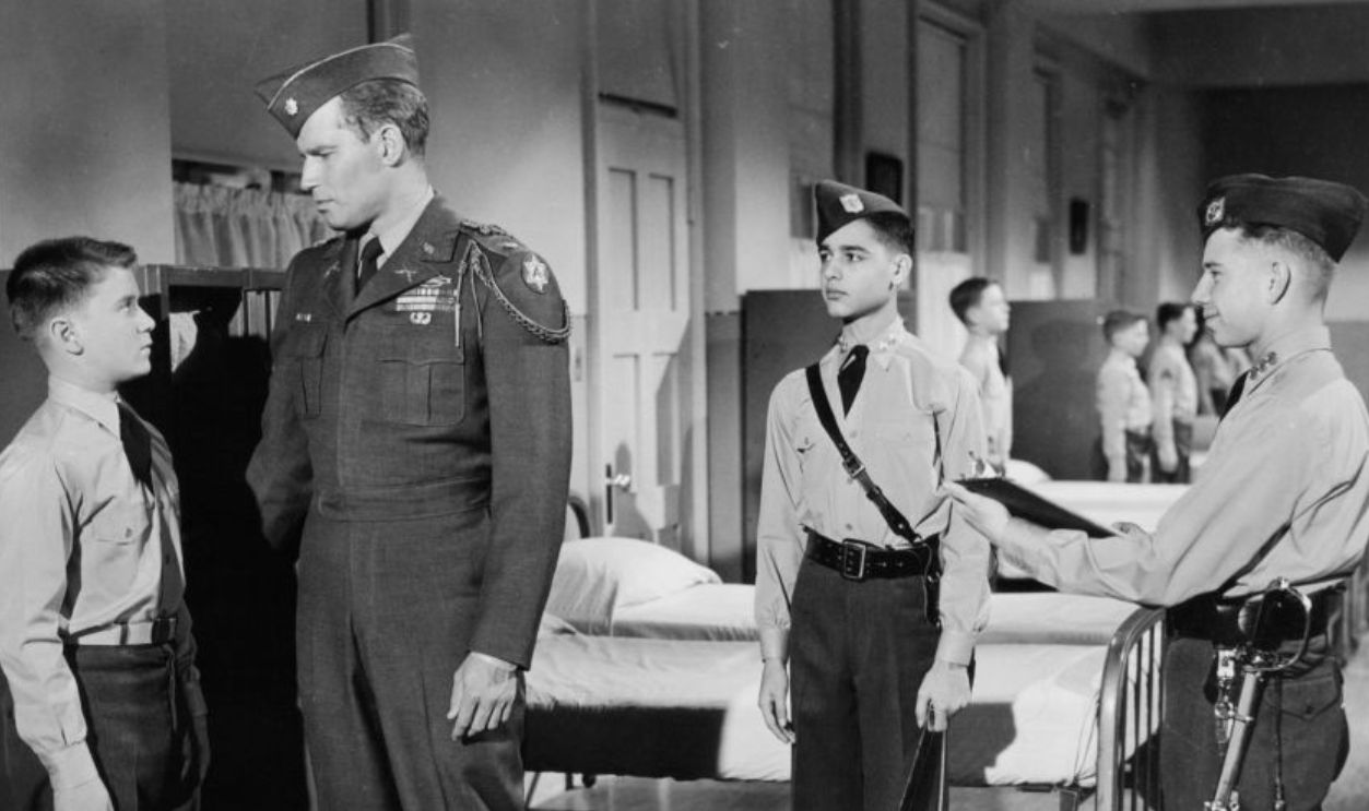 Charlton Heston talking to boy as two others watch in a scene from the film 'The Private War Of Major Benson', 1955.