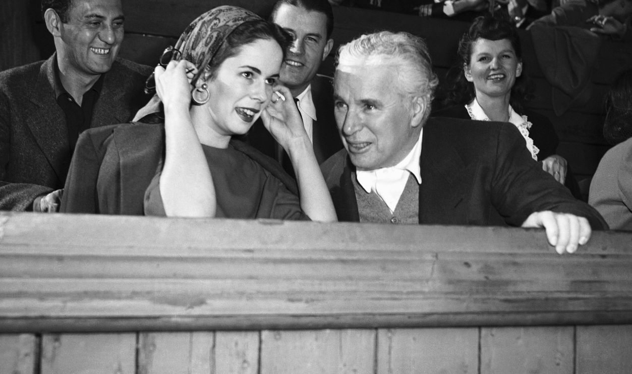 Charlie and Oona Chaplin Watching a Tennis Match (Original Caption) The Chaplins Re-Enter Social Life. Los Angeles, California: Comedian Charlie Chaplin and his wife, Oona O'Neill, showed up in public for the first time since the actor injured his leg and ankle during the time of Joan Barry's paternity suit against him. They attended a war fund benefit tennis meet at which racquets of the players were auctioned off. Chaplin bid up to $300 on Bill Tilden's racquet, dropped out when Barbara Hutton, the dime store heiress, bid twice as much.