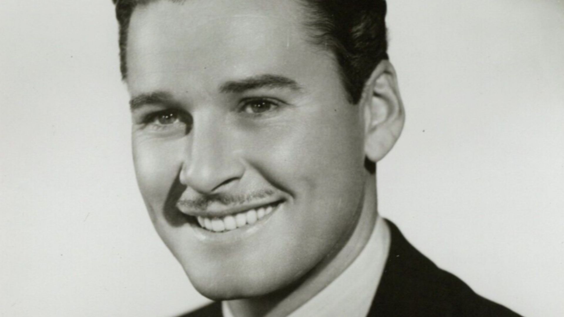 This is a publicity photo, circulated for publicity, of Errol Flynn, published in 1936 without copyright notice, qualifying it under public domain.