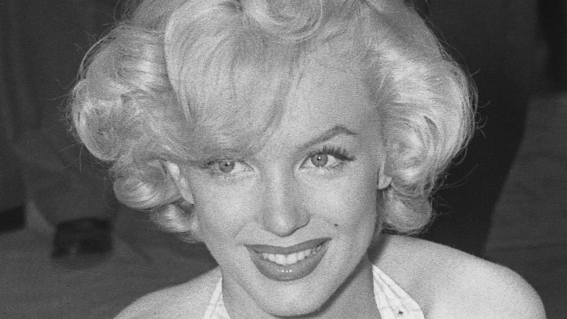 Marilyn Monroe and Jane Russell putting signatures, hands and foot prints in wet concrete at Chinese Theater in Los Angeles, Calif., 1953