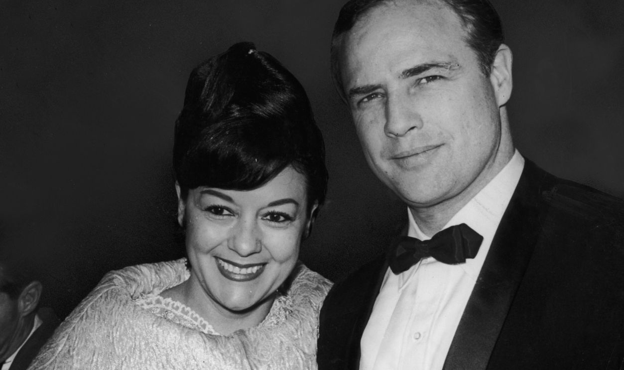 Movita And Marlon circa 1961: American actor Marlon Brando smiles while standing arm in arm with his second wife, Movita Castenada, at a formal event.