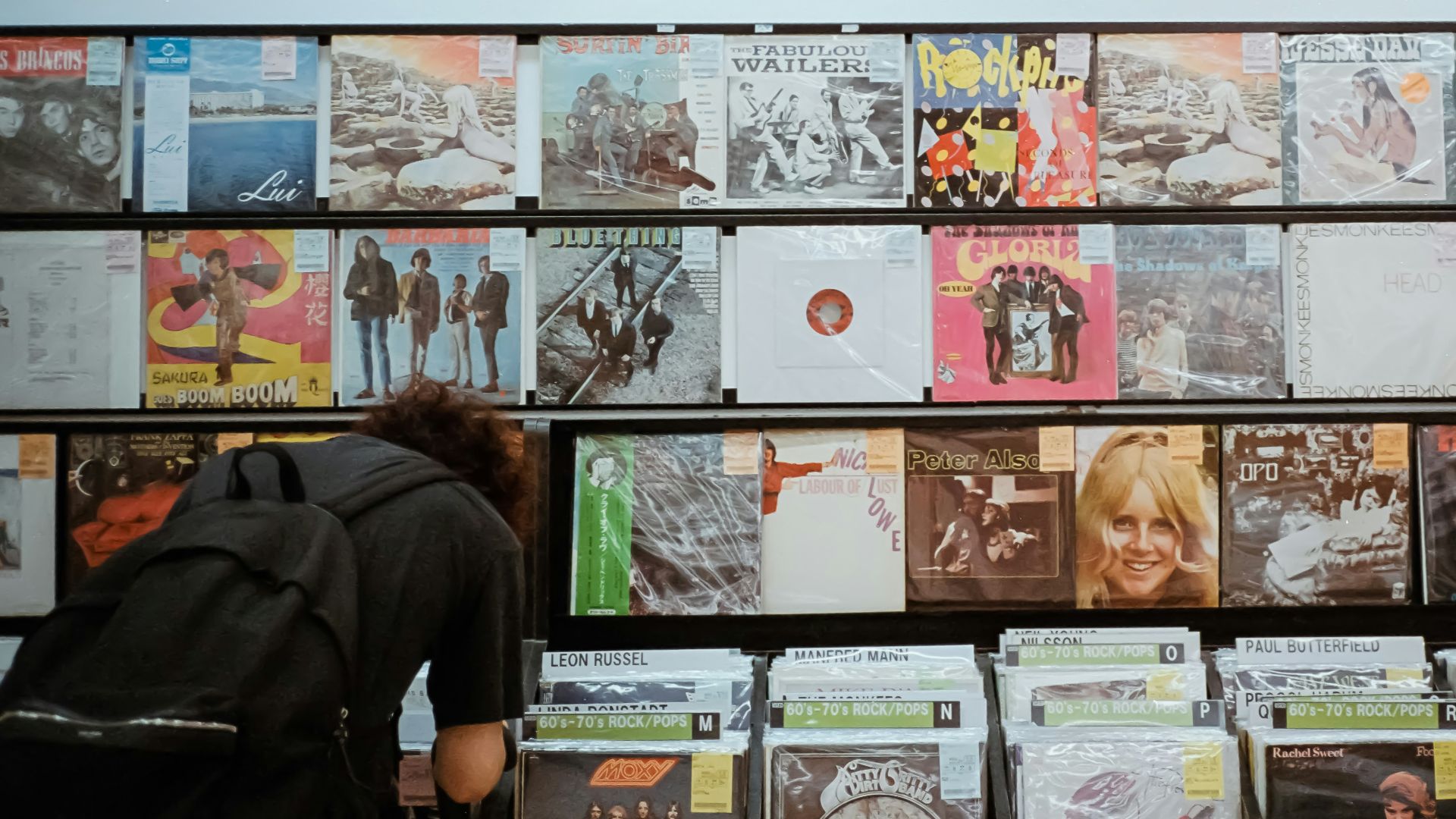 a man is looking at a wall of records