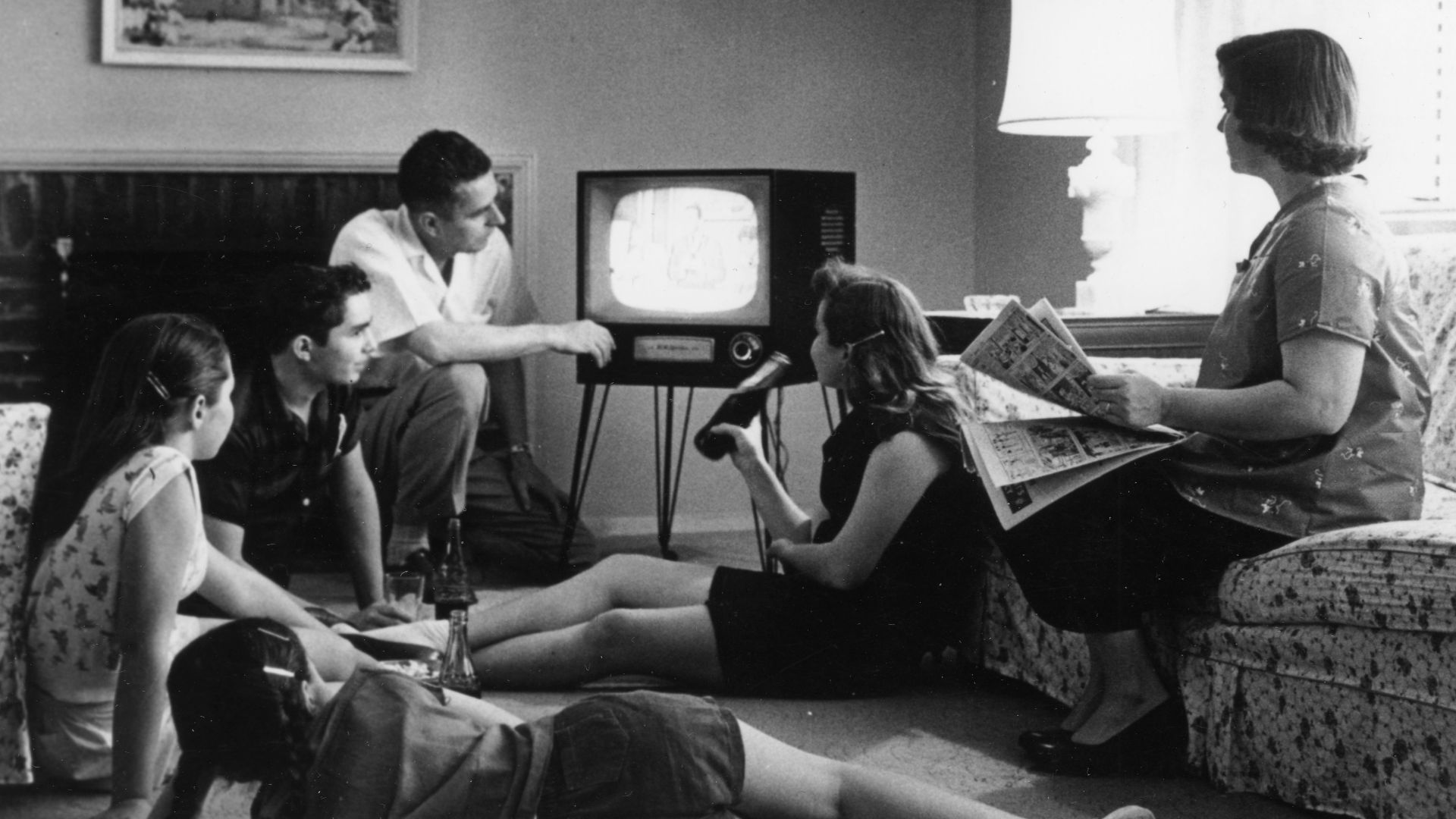 Family watching television in their home, c. 1958