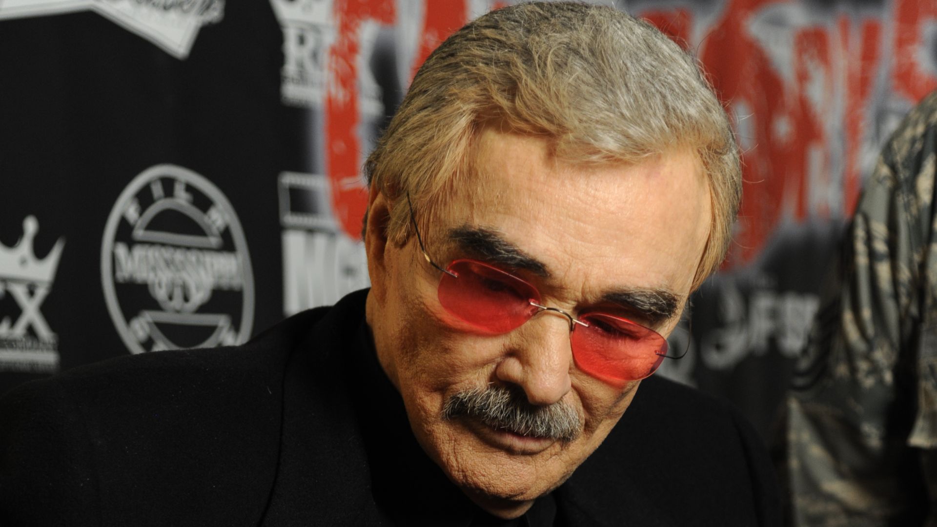 Burt Reynolds signs posters for Keesler personnel prior to the movie premiere of “Category 5” Oct. 22, 2014, at the Bay Breeze Event Center, Keesler Air Force Base, Miss. A reception and autograph session with the cast and crew also took place following t