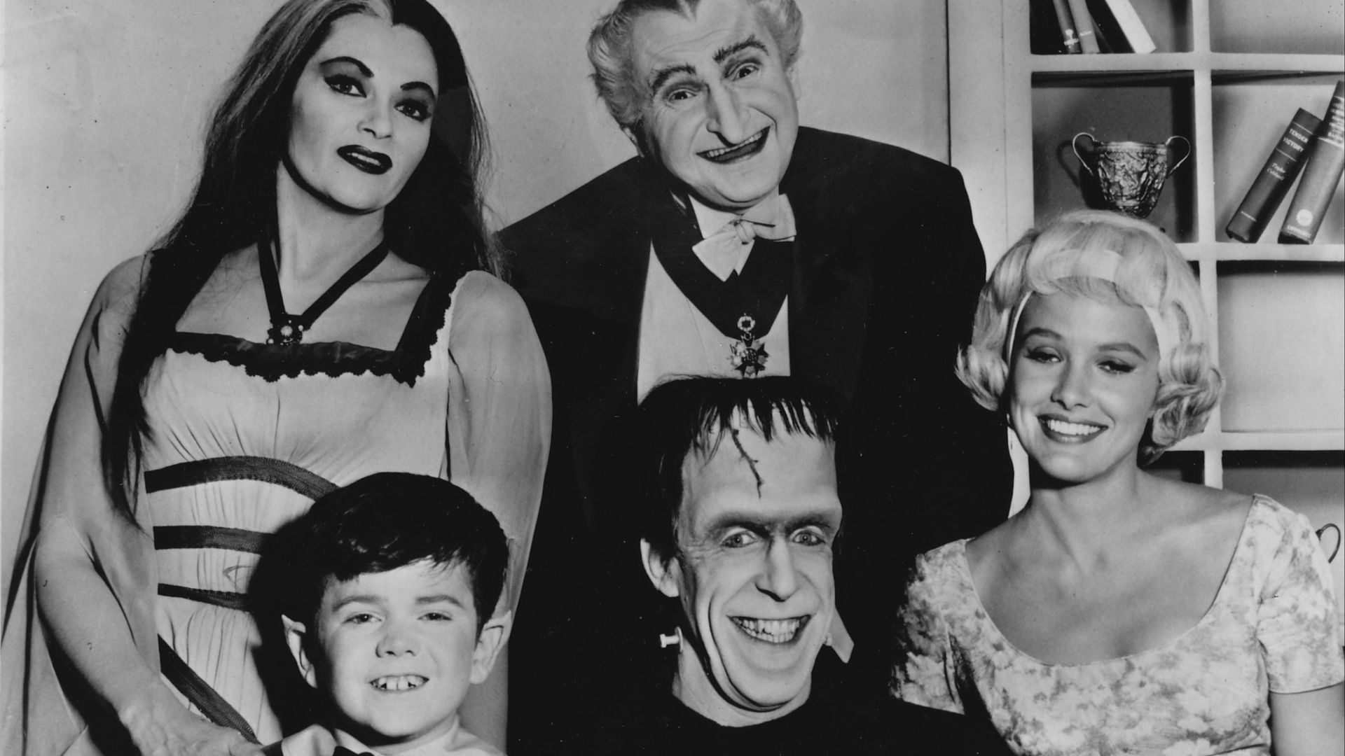 Publicity photo of television actors, (sitting; L–R) Butch Patrick, Fred Gwynne, Beverley Owen, (standing; L–R) Yvonne De Carlo and Al Lewis promoting their roles on the CBS comedy series The Munsters.
